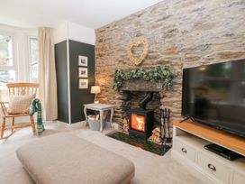 A living room with a fireplace and television at The Wonky Nest in Bowness-On-Windermere