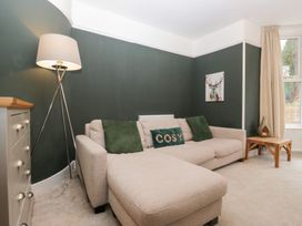 A living room with a sofa and lamp at The Wonky Nest in Bowness-On-Windermere