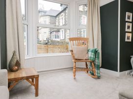 A living room with a rocking chair and a wooden table at The Wonky Nest Bowness-On-Windermere