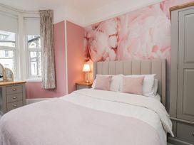 A bedroom with a bed and bedside lamp at The Wonky Nest in Bowness-On-Windermere