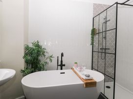 A bathroom with a bathtub and shower at The Wonky Nest in Bowness-On-Windermere