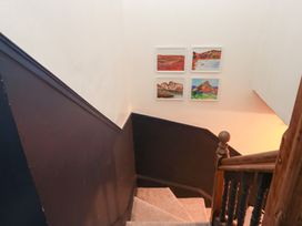A staircase with framed artwork on the wall at The Wonky Nest in Bowness-On-Windermere