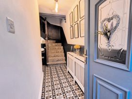 A hallway with a staircase and a console table at The Wonky Nest in Bowness-On-Windermere