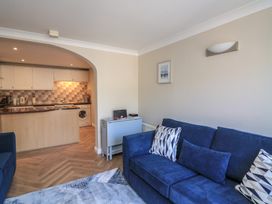 A living room with a sofa and kitchen in 6 Dartmouth House Dartmouth