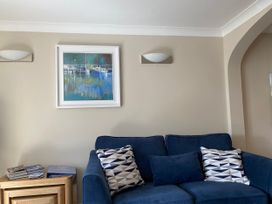 A living room with a blue sofa and paintings at 6 Dartmouth House in Dartmouth
