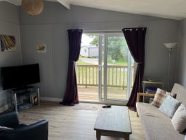 A living room with a television and sofa at Chalet 3 Wipeout in Hayle