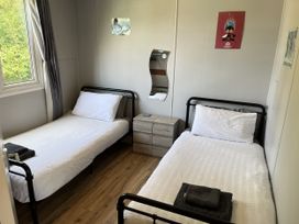 A bedroom with two single beds and a mirror at Chalet 3 Wipeout in Hayle