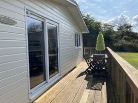 An outdoor deck with a table and chairs at Chalet 3 Wipeout in Hayle