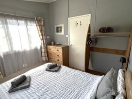 A bedroom with a bed and furniture at Chalet 3 Wipeout Hayle