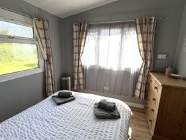 A bedroom with a bed and towels on top at Chalet 3 Wipeout in Hayle