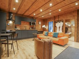 A living room with a sofa and kitchen area at Bee Hive in South Luffenham near Edith Weston