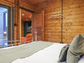 A bedroom with a bed and wooden walls at Bee Hive in South Luffenham near Edith Weston