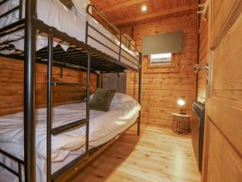 A bedroom with a bunk bed and lamp at Bee Hive South Luffenham near Edith Weston