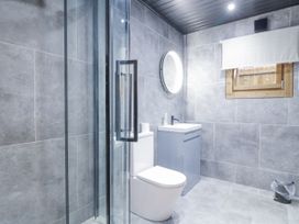 A bathroom with a shower, toilet, sink, and mirror at Bee Hive South Luffenham near Edith Weston