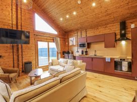 A living room with a sofa and kitchen area at Rabbit Hole near Stamford