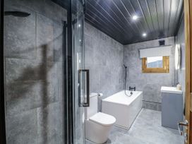 A bathroom with a shower, bathtub, toilet, and sink at Rabbit Hole near Stamford