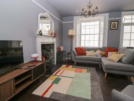 A living room with a sofa and television at Unicorn Cottage