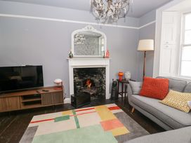 A living room with a television and fireplace at Unicorn Cottage 