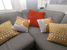 A sofa with patterned cushions at Unicorn Cottage