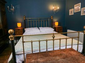 A bedroom with a bed and nightstands at Unicorn Cottage