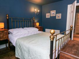 A bedroom with a bed and nightstands at Unicorn Cottage in 