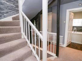 A hallway with stairs and a door at Unicorn Cottage