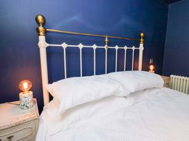 A bedroom with a bed and nightstand at Unicorn Cottage