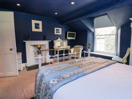 A bedroom with a bed and a desk at Unicorn Cottage in 