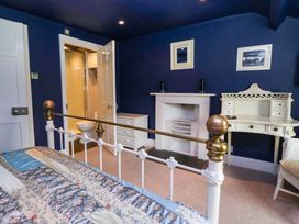 A bedroom with a bed and a bathroom door at Unicorn Cottage