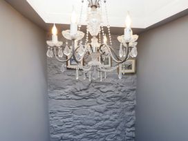 A chandelier with wall pictures in a hallway at Unicorn Cottage