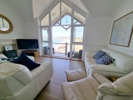 A living room with a sofa and television at Sea View Beach Apartment in Thurlestone