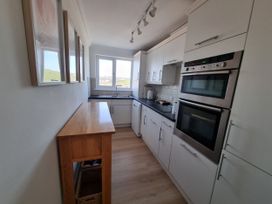 A kitchen with cabinets, sink, and oven in Sea View Beach Apartment Thurlestone