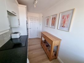 A kitchen with a toaster and a cabinet at Sea View Beach Apartment Thurlestone
