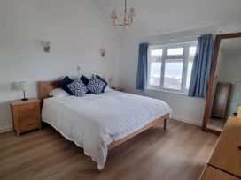 A bedroom with a bed and bedside lamps at Sea View Beach Apartment in Thurlestone