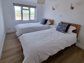 A bedroom with two beds and a window at Sea View Beach Apartment Thurlestone