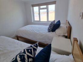 A bedroom with two beds and a window at Sea View Beach Apartment Thurlestone