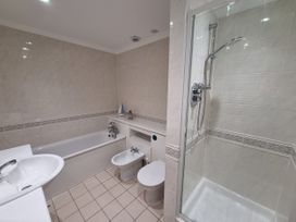 A bathroom with bathtub, shower, toilet, bidet and sink at Sea View Beach Apartment in Thurlestone