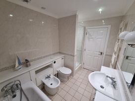 A bathroom with a bathtub, bidet, toilet, sink, and shower at Sea View Beach Apartment in Thurlestone