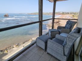 A balcony with deck chairs and ocean view at Sea View Beach Apartment Thurlestone