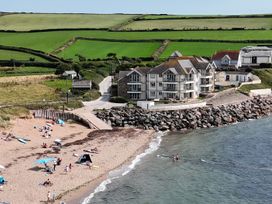 A beach with people sunbathing and swimming at Sea View Beach Apartment in Thurlestone