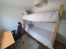 A bedroom with a bunk bed and a desk at Sea View Beach Apartment in Thurlestone