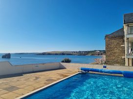 An outdoor area with a swimming pool overlooking the ocean at Sea View Beach Apartment Thurlestone