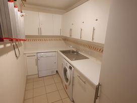 A laundry room with a washing machine and a dishwasher at Sea View Beach Apartment Thurlestone