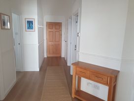 A hallway with a console table and artwork at Sea View Beach Apartment in Thurlestone