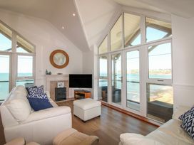 A living room with a sofa and television at Seaview Beach Apartment, 11 Thurlestone Rock Thurlestone
