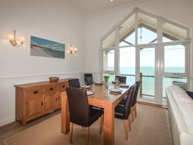 A dining room with a table, chairs and a sideboard at Seaview Beach Apartment, 11 Thurlestone Rock, Thurlestone