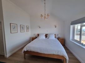 A bedroom with a bed and nightstands at 11 Thurlestone Rock in Thurlestone