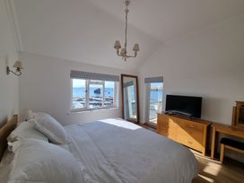 A bedroom with a bed and television at 11 Thurlestone Rock in Thurlestone