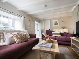A living room with couches and a coffee table at Rock View in Trethurgy near St Austell