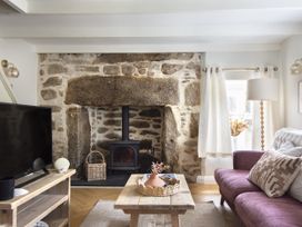 A living room with a television and fireplace at Rock View in Trethurgy near St Austell